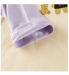 Close-up of raglan sleeve cuffs with double-needle stitching and cartoon bear pattern