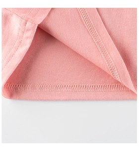 Détail du tissu en coton rose montrant la double couture de qualité sur l'ourlet