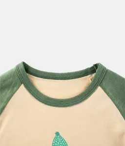 Detailed close-up of ribbed crewneck and raglan sleeve stitching on girl's cotton tee