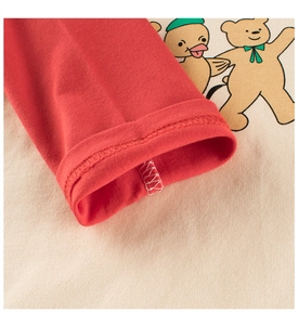 Detail of red sleeve cuff and bird print on cotton long-sleeve tee for kids