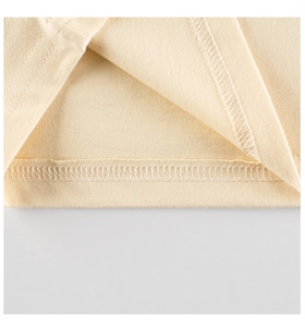 Detail view of the cream cotton knit hem with double-needle stitching on kids long sleeve tee