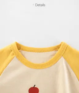 Close-up of baby t-shirt collar with yellow raglan sleeves and fine knit cotton texture