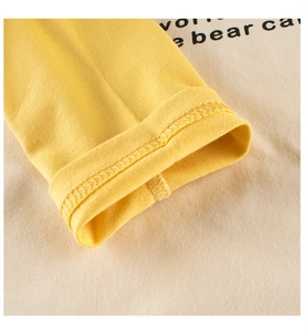 Detailed close-up of yellow knit cuffs with quality overlock stitching and soft fabric texture