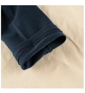 Detail of double-needle cuffs on long-sleeve cotton T-shirt with blue raglan sleeves