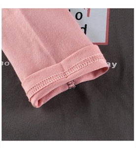 Detailed close-up of pink and grey sleeves with high-quality stitching on kids' shirt
