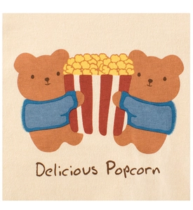 Detailed view of the cute bear popcorn print and cotton texture on a yellow toddler T-shirt