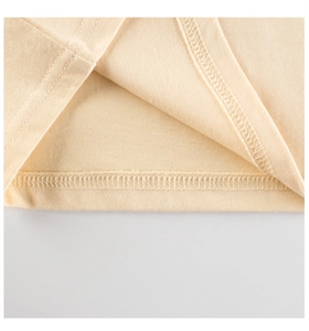 Close-up of double-needle stitching on the hem of a light beige cotton knit T-shirt