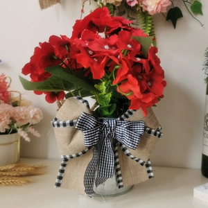 Detailed macro of red geranium basket with rustic metal bucket and burlap bow ornament