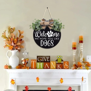 Welcome wooden door sign with eucalyptus leaves and dog-friendly quote on a wall