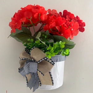 Artificial Christmas hanging basket with red geraniums, green leaves and a plaid bow