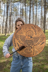 Outdoor close-up of a Shamanic bird drum with brown leather surface and drumstick