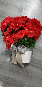 Close-up of artificial red geranium hanging basket with black and white plaid bow decoration