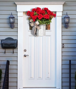 Detail of red geranium hanging basket with a black and white checkered bow decoration