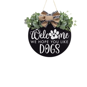 Rustic round welcome sign with eucalyptus leaves and dog paw print for front door
