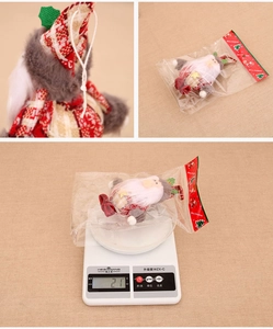 Detail of Christmas gnome ornament with red plaid hat and festive gift packaging