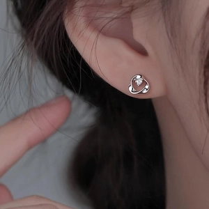 Elegant silver Mobius loop earrings with sparkling zircon stud on model ear