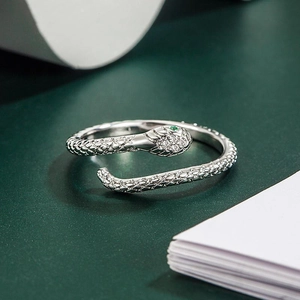 Elegant silver snake ring with green gemstone eyes and sparkling white diamonds