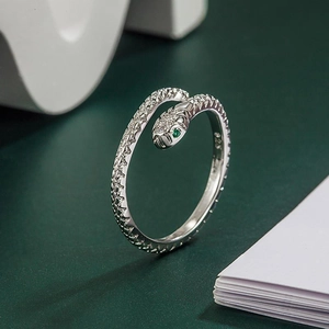 Macro view of S925 silver snake ring featuring green gem eyes and sparkling zircons