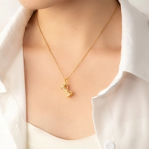 Élégant collier sablier doré avec accents en zircone porté par un mannequin femme