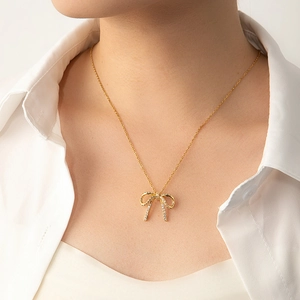 Elegant gold bow pendant necklace with sparkling zircon pavé on a delicate chain
