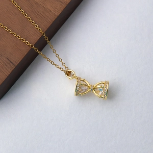 Collier nœud doré élégant serti de zircons et pierres centrales en forme de poire