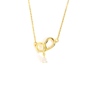 Detailed view of gold necklace with zircon pavé ring and pear-shaped white drop pendant