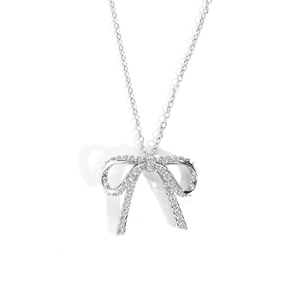 Detailed close-up of a silver bow necklace pendant featuring sparkling zircon stones