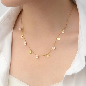 Gold-plated choker necklace featuring white enamel flowers and butterfly charms on a model
