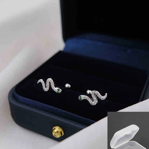 Snake stud earrings with pavé crystals and green gem eyes in a blue velvet gift box