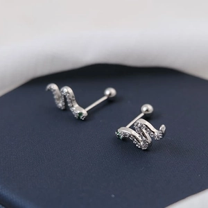 Serpentine silver cartilage stud earrings with sparkling pavé stones and green gem eyes
