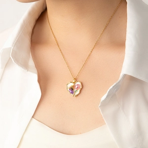 Détail du collier pendentif cœur avec émail blanc et pierres précieuses sur chaîne dorée