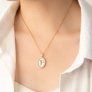 Détail du collier à fleurs avec pendentif ovale en nacre et petites perles blanches