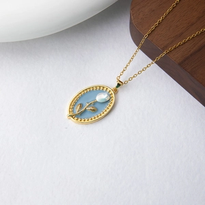 Détail du pendentif tulipe en émail bleu de luxe français avec cadre doré et bord perlé