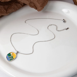 Gros plan du pendentif fleur en émail de luxe avec perle et chaîne dorée