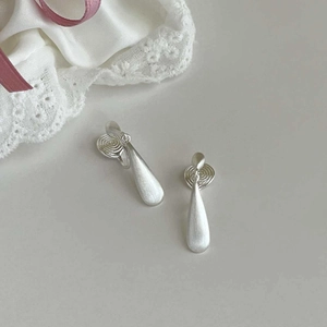 Detail view of silver teardrop earrings with matte brushed finish and spiral texture