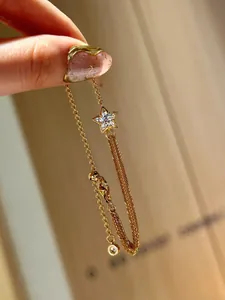Detail of 18K gold star bracelet with zircon inlay and adjustable lobster clasp