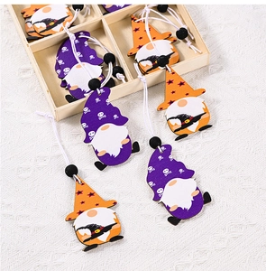 Détail de pendentifs gnomes d'Halloween en bois avec motifs de crânes dans une boîte