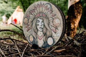 Close-up of Shamanic hand drum with Native American woman art in a forest setting