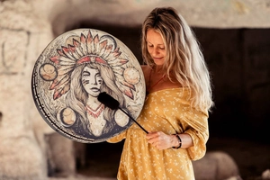Detailed view of handmade shaman drum with Native American woman art and wooden mallet