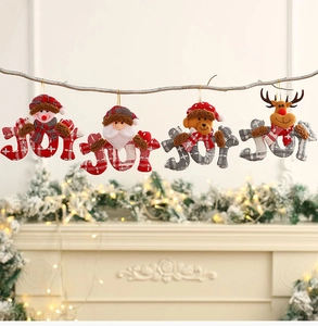 Detail of JOY letter Christmas ornaments with plush Santa and Snowman hanging on branches