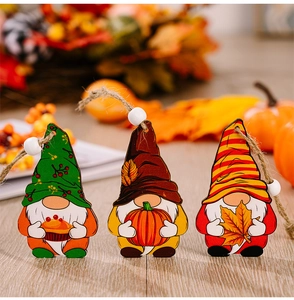 Detailaufnahme von Herbst-Gnome-Holzornamenten mit Kürbis- und Ahornblatt-Motiven