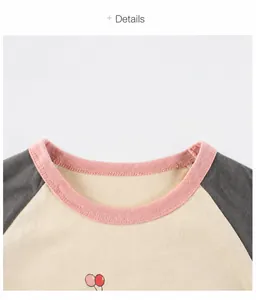 Close-up of girl's cotton T-shirt showing pink ribbed neckline and balloon print details