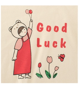 Detail of cartoon girl with balloon and Good Luck text on beige cotton T-shirt