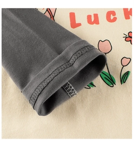 Detail of color-block knit sleeve and tulip print on toddler girl's long-sleeve tee