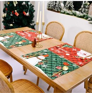 Christmas placemats featuring Santa Claus and snowman patterns on festive plaid fabric