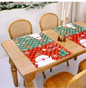 Detail of red and green plaid Christmas placemats with Santa Claus on a wooden table