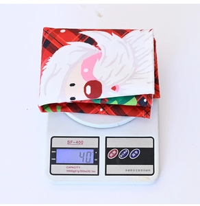 Close-up of a 40g Christmas plaid placemat with Santa Claus print on a digital scale