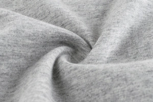 Macro shot of soft heather grey knitted cotton fabric showing high-quality texture and draping