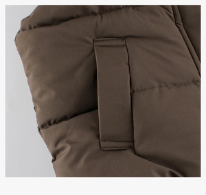 Detail of dark brown quilted puffer vest showing durable side pocket and stitching