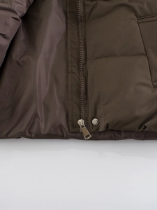 Kids' winter puffer vest in dark brown featuring a high collar and metal zipper closure